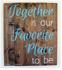 a sign that says together is our favorite place to be on a wooden fence with blue lettering