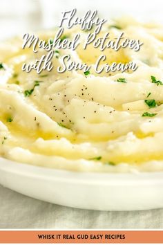 mashed potatoes with sour cream in a white bowl on top of a tablecloth