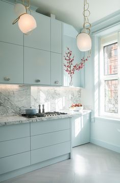 a kitchen with blue cabinets and marble counter tops