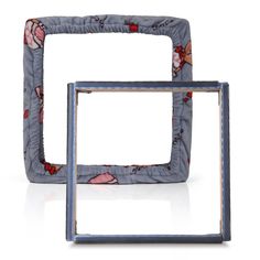 two square frames with flowers on them sitting next to each other in front of a white background