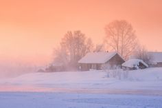 a snowy landscape with houses and trees in the foreground, on a cold day