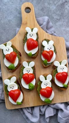 several small sandwiches with different toppings on a cutting board