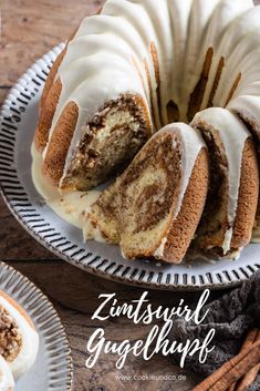 a bundt cake with white frosting and cinnamon swirl on top, sitting on a plate