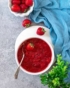 a bowl of strawberries is next to two bowls of berries and a blue towel