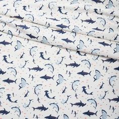 a white sheet with blue sharks on it