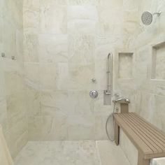 a walk in shower sitting next to a wooden bench