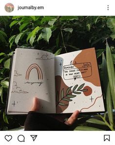 someone is holding an open book in front of some plants and trees with the words journal em written on it