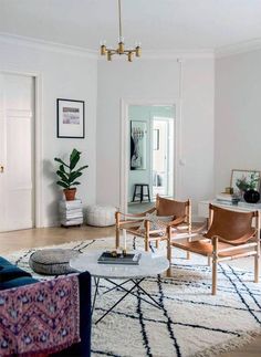 a living room filled with furniture and a potted plant on top of a table