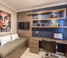 a living room with a couch, desk and bookshelves on the wall above it