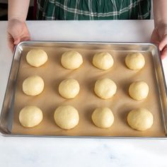 a person holding a pan filled with dough