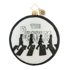 an ornament with the beatles on it's side and people walking across