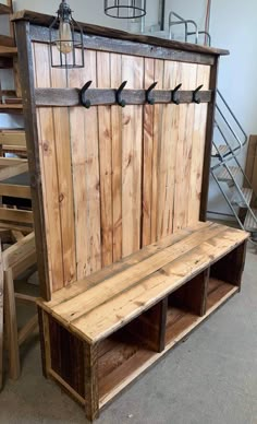 a bench made out of pallet wood with hooks on it