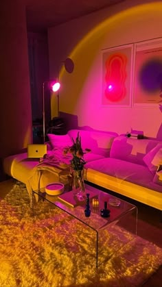 a living room filled with furniture and pink lighting