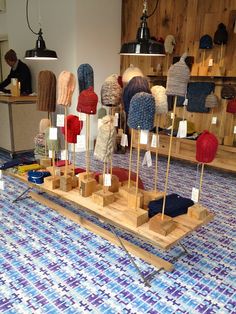 a wooden stand with hats on it in the middle of a store floor and an ad for