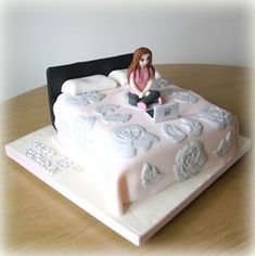 a cake with a woman sitting on top of it