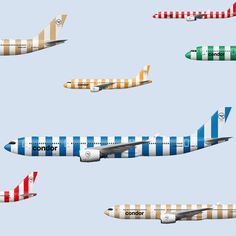 several different colored airplanes are flying in the sky with white and blue stripes on them