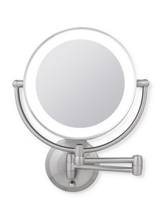 a round mirror mounted on the side of a wall with two arms and one arm