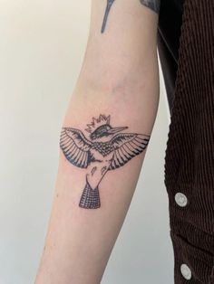 a bird with a crown tattoo on its arm