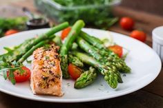 salmon, asparagus and tomatoes on a white plate