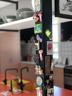 there are many magnets attached to the pole in this kitchen area, and it's so cute