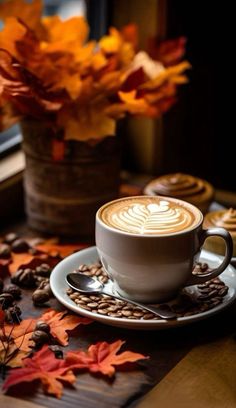 a cappuccino on a saucer surrounded by autumn leaves