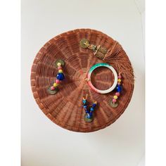 a wicker tray with beads and bracelets on it, hanging from the wall