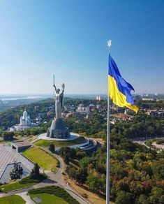 an aerial view of the statue of liberty in ukraine with a flag flying next to it