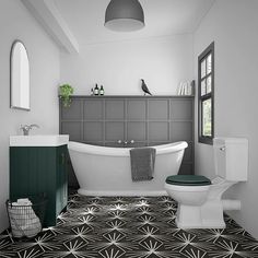 a bathroom with black and white flooring and a bathtub in the center, along with a toilet and sink