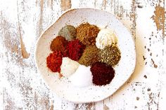 a white bowl filled with spices on top of a wooden table