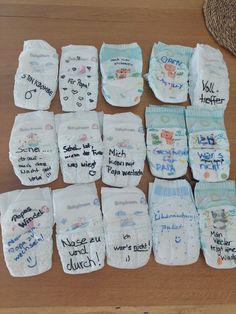 baby diapers are laid out on the floor with writing all over them, including names and pictures