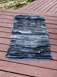 a pile of blue jeans sitting on top of a wooden floor next to a park