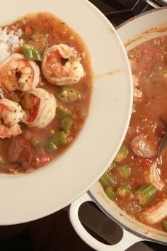 a white bowl filled with shrimp and rice next to a pot of soup on top of a stove