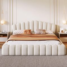 a white bed sitting on top of a wooden floor next to two nightstands with lamps