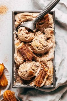 a pan filled with ice cream next to other desserts