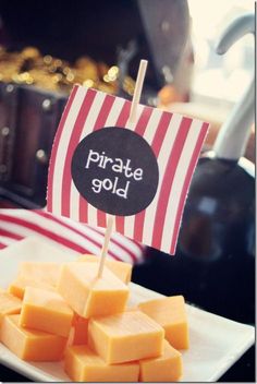 there is a plate with cheese on it and a small sign that says pirate gold