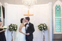 a bride and groom kissing in front of the alter