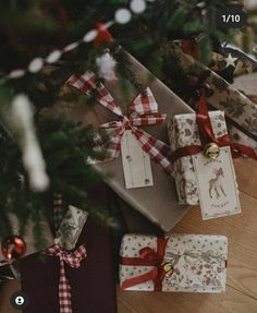 presents under the christmas tree are wrapped in red and white ribbon