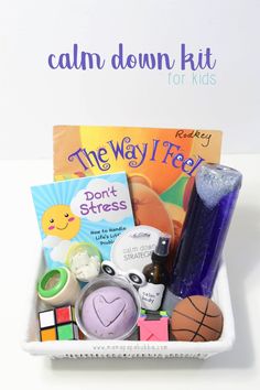 a basket filled with books and toys on top of a white table next to a sign that says calm down kit for kids