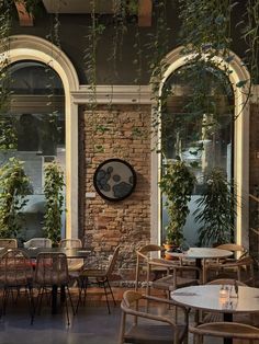 an outdoor restaurant with tables and chairs covered in ivys, surrounded by arched windows