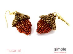 two pairs of gold tone earrings with red beads hanging from hooks on a white background