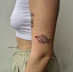 a woman's arm with a fish tattoo on the left side of her right arm