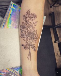 a woman's arm with a flower tattoo on it