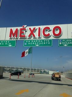 an exit sign for mexico with cars driving under it