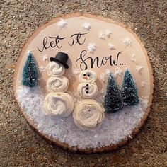 a wooden sign with snowmen and trees on it