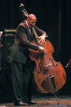 a man in a suit playing an instrument on stage