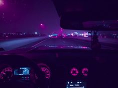 the dashboard of a car at night with lights on and purple hues in the background