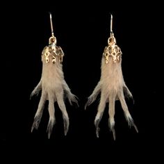 two pairs of earrings with feathers hanging from them