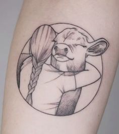 a woman's thigh with a tattoo of a cow and braids on it