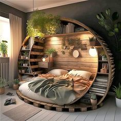 a round bed in the middle of a room with bookshelves and plants on it