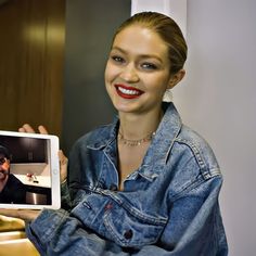 a woman holding up an ipad with a man on the screen